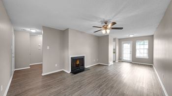 A spacious room with a fireplace and a ceiling fan.